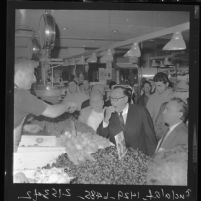 Governor Edmund G. (Pat) Brown tastes strawberry as he tours Los Angeles' Grand Central Market in 1962