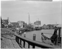 Man leans against a docked boat on the waterfront in Holland, 1929