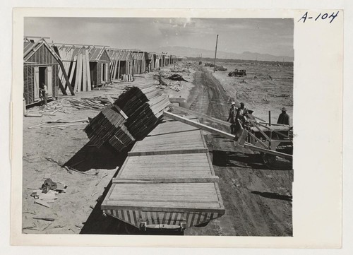 Site No. 1. Unloading lumber with bulldozer in the construction of barracks for evacuees of Japanese ancestry who will spend the duration in War Relocation Authority centers. Photographer: Clark, Fred Poston, Arizona